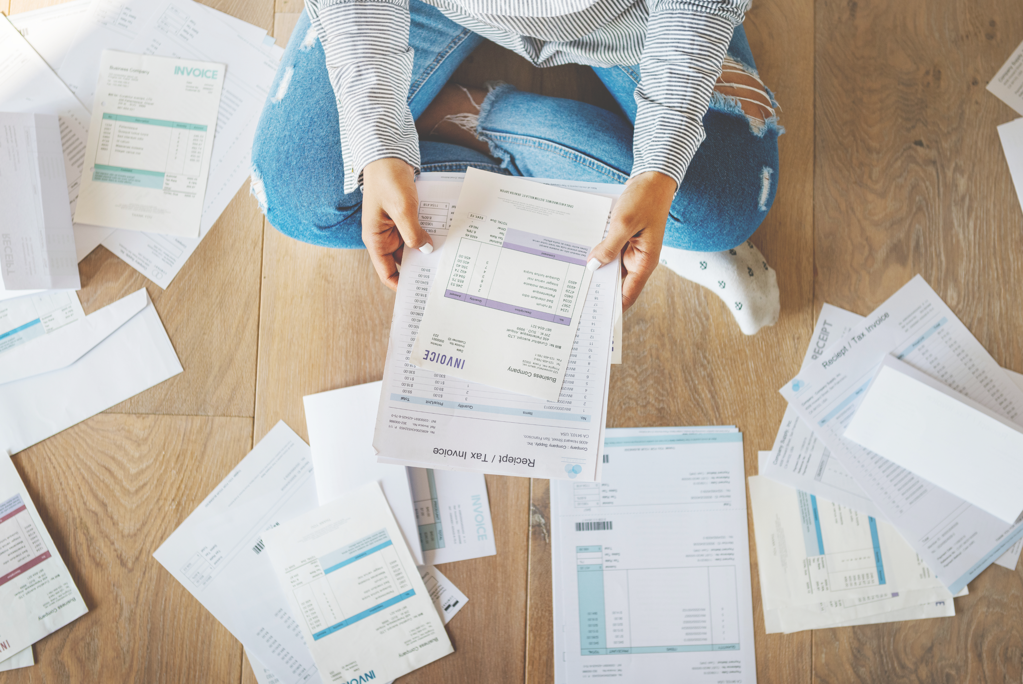 person sitting on the ground with paper bills